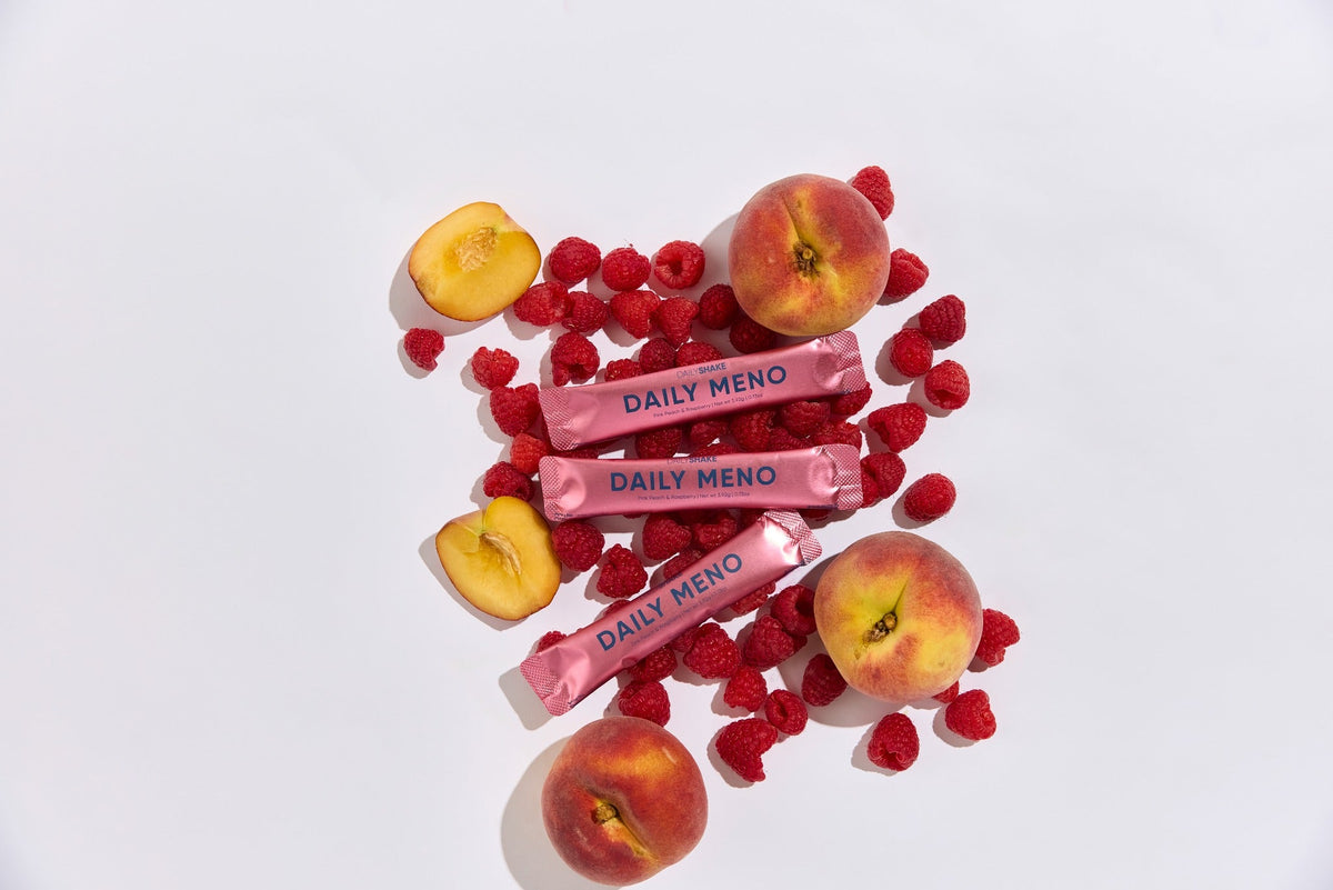 Daily Meno sachets styled with fresh peaches and raspberries